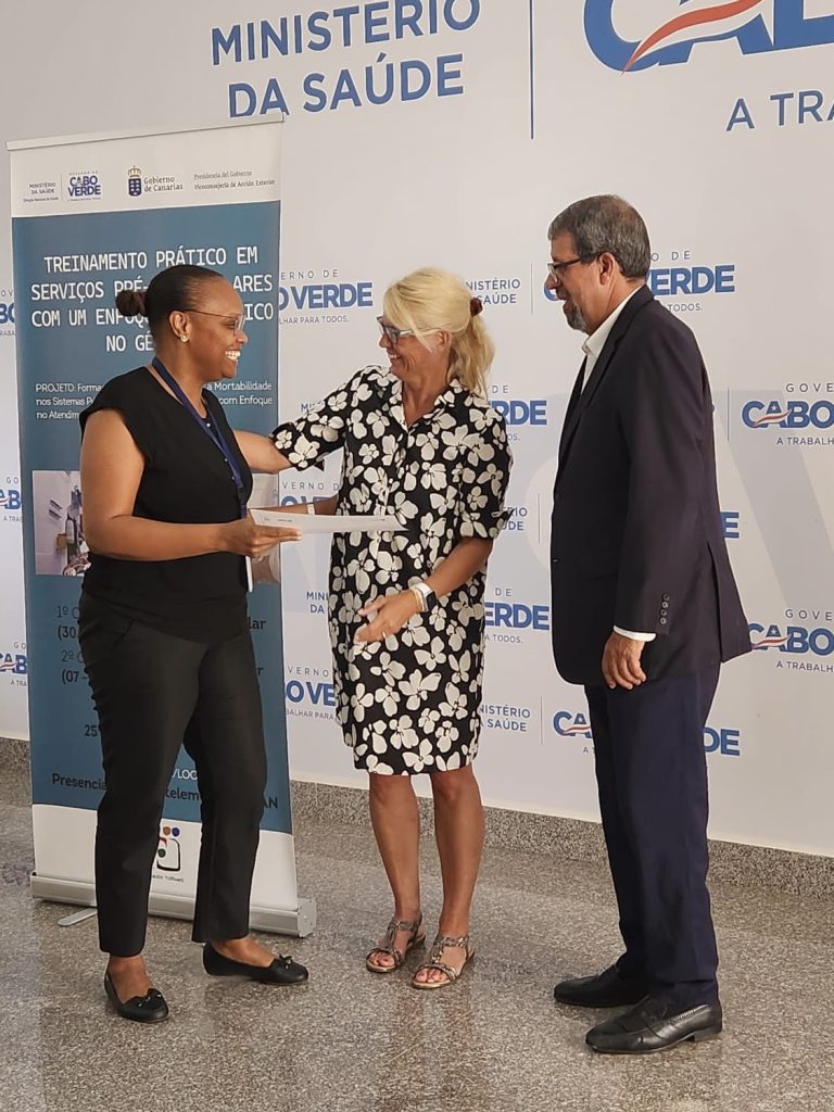 3 personas en la entrega de un diploma en Cabo Verde